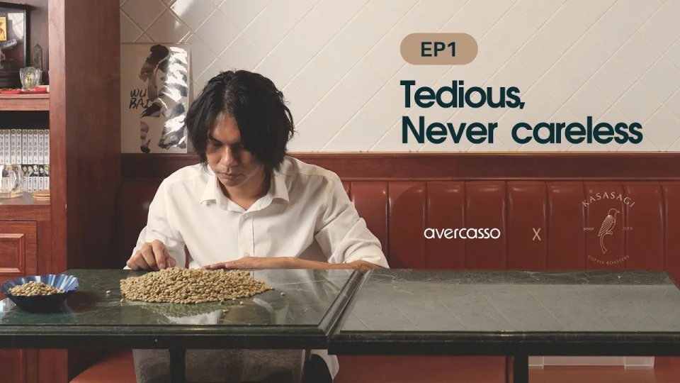 Kasasagi Coffee owner Jin Wan carefully sorting green coffee beans at the table, reflecting craftsmanship and dedication to detail.