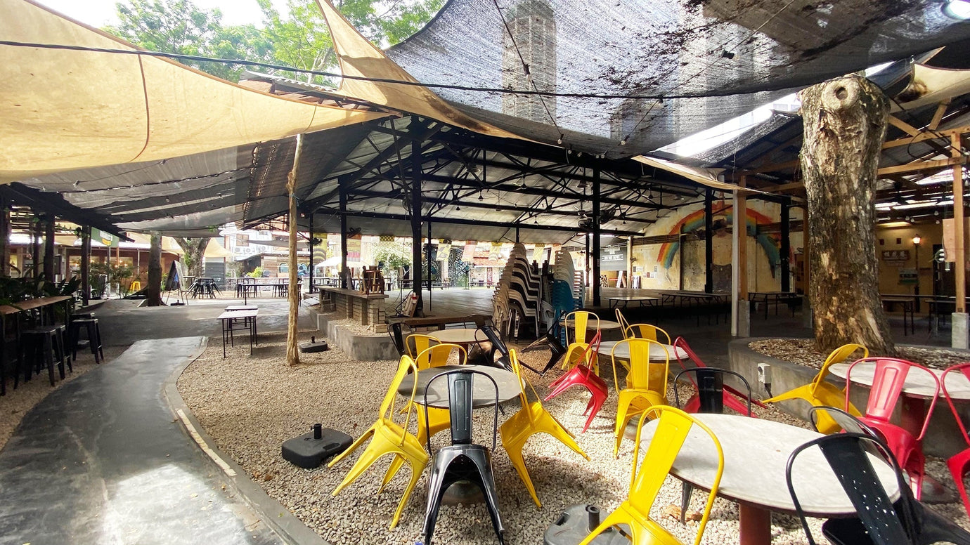 Hin Bus Depot Penang, open-air industrial venue with colorful chairs for coffee culture.