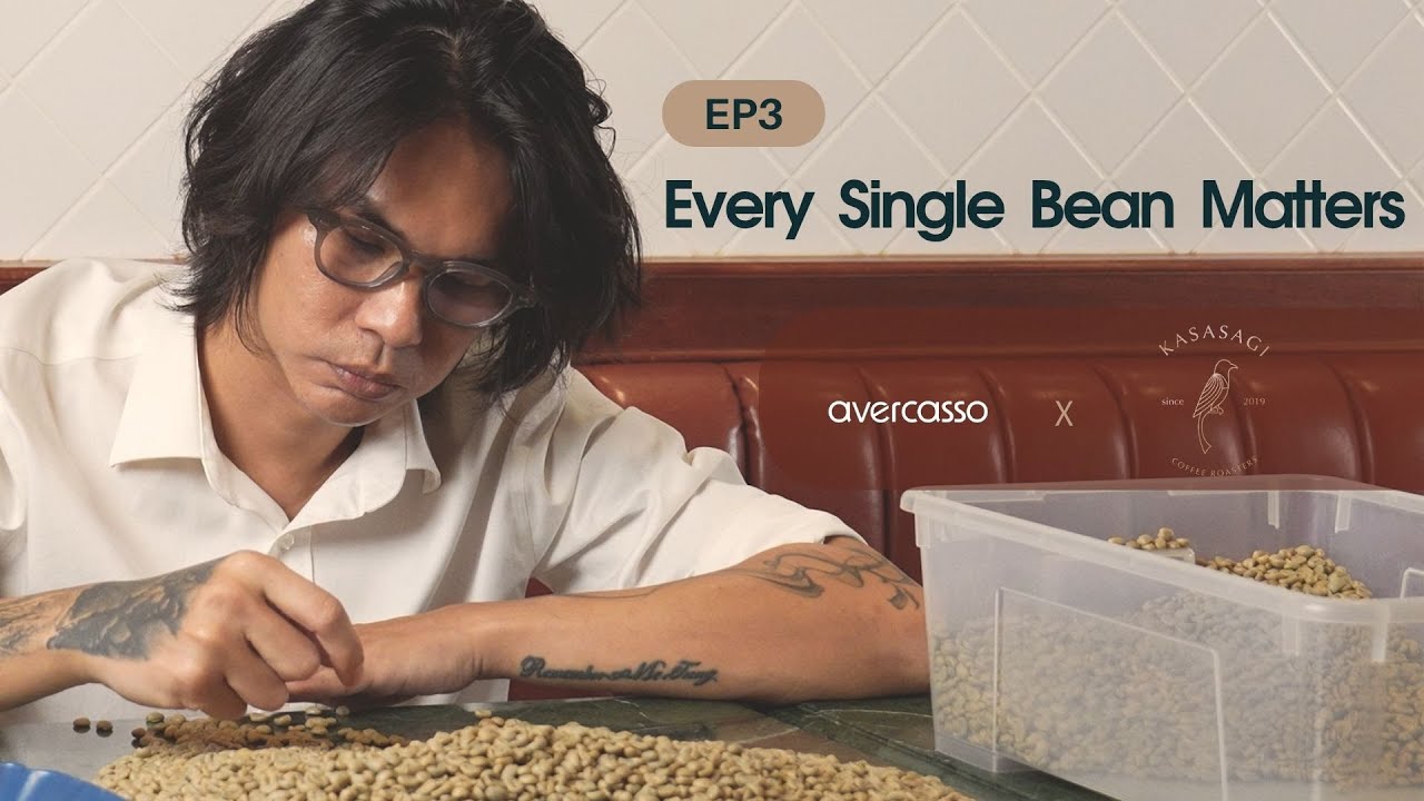 Kasasagi Coffee owner carefully sorting each green coffee bean at the table, ensuring uncompromised quality through meticulous attention.