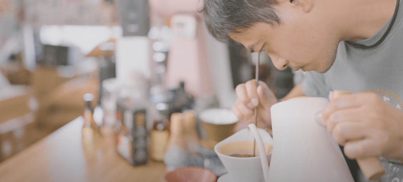 RiSan Coffee founder, Mr. Huang, meticulously hand-brewing coffee inside his Japanese-style cafe, showcasing his craftsmanship and dedication to quality.